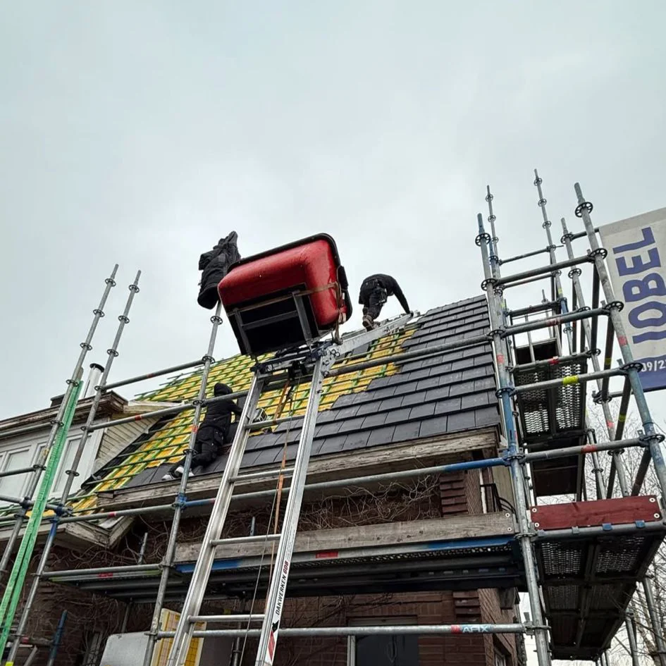 Dakwerker aan het werk op een hellend dak - vakmanschap Dakwerken Vandevyver